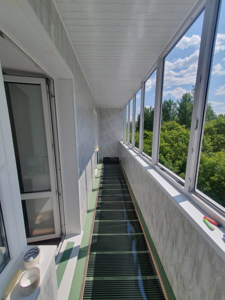 На лоджии обшиты потолок и стена, на пол укладывается греющий мат