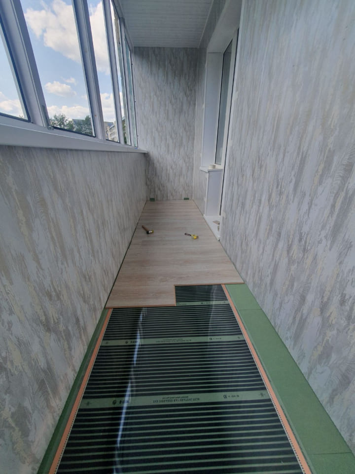 Греющий мат уложен на пол лоджии и начат процесс укладки ламинат